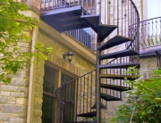custom wrought iron spiral staircase connected to porch railing from finelli architectural iron and stairs